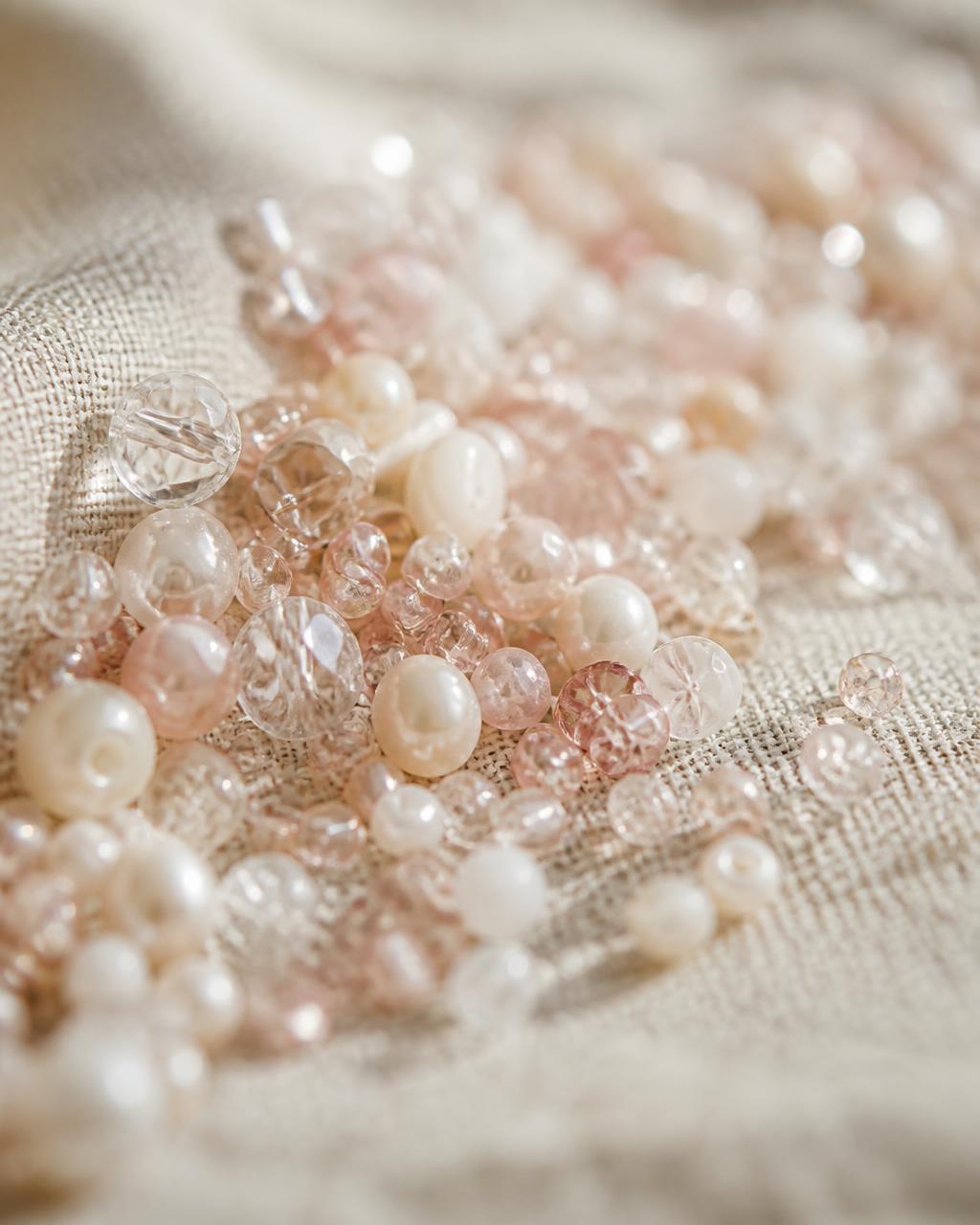 Close up of loose glass beads resting on soft linen